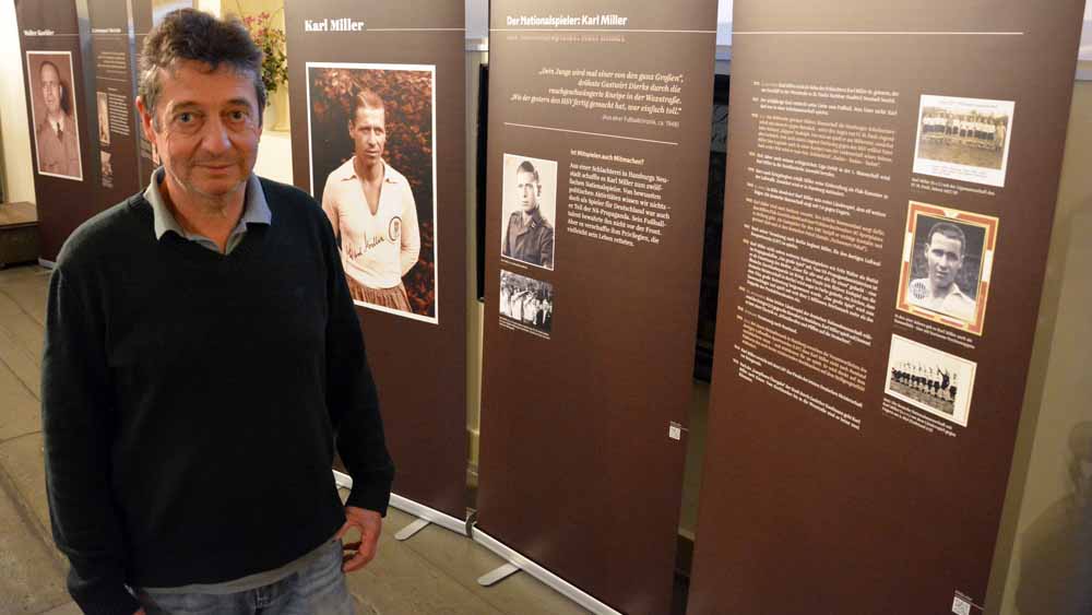 Pastor Martin Paulekun vor der Schautafel über Nationalspieler Karl Miller