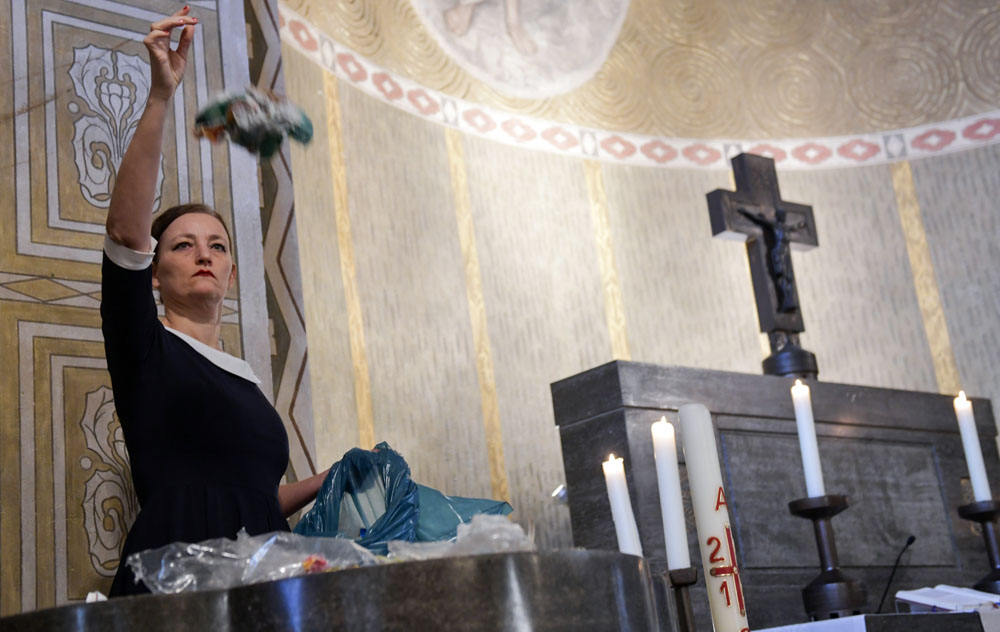 Künstlerin Swaantje Güntzel in Aktion vor dem Altar Foto: Hermann Pentermann / epd