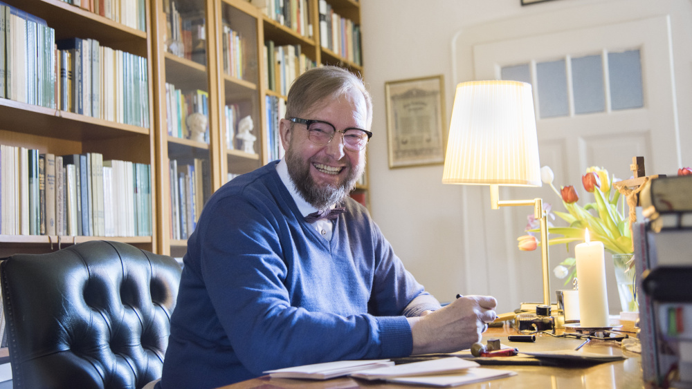 Diakon Dirk Hartung hat an seinem Schreibtisch eine Kerze angezündet. Mit seinem Füller mit der goldenen Feder schreibt er Karte um Karte an Menschen, die sonst zu seinen Angeboten für Senioren kommen.