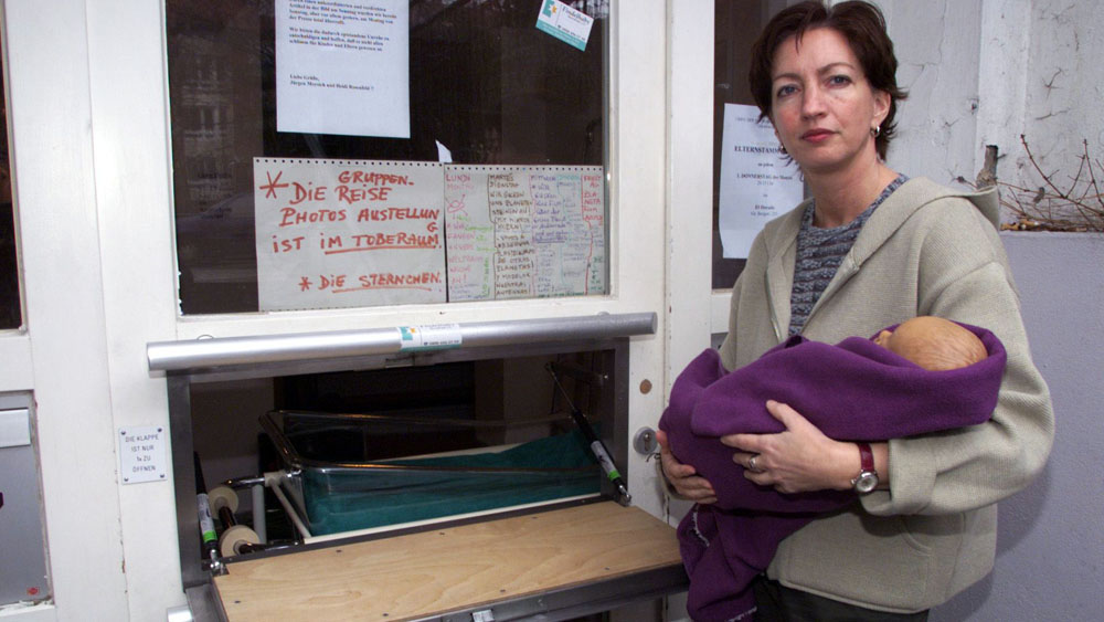 Heidi Rosenfeld von der Kindertagesstätte "SterniPark" in Hamburg erläutert vor dem Start im April 2000 die Babyklappe mit einer Puppe