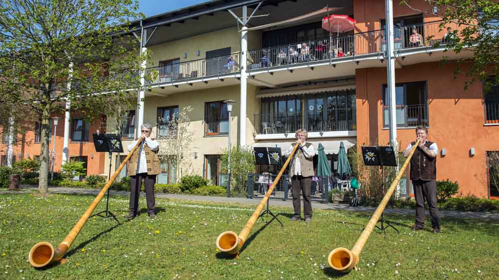 Die Alpenbläser "Alptraumtrio" spielen vor dem Altenzentrum Vinzenz-von-Paul-Haus in Idstein (Hessen)