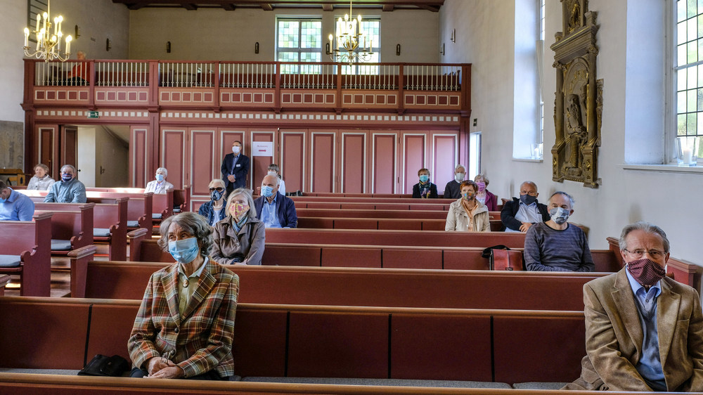 Während des Gottesdienstes tragen die Besucher Masken Foto: Jens Schulze / epd
