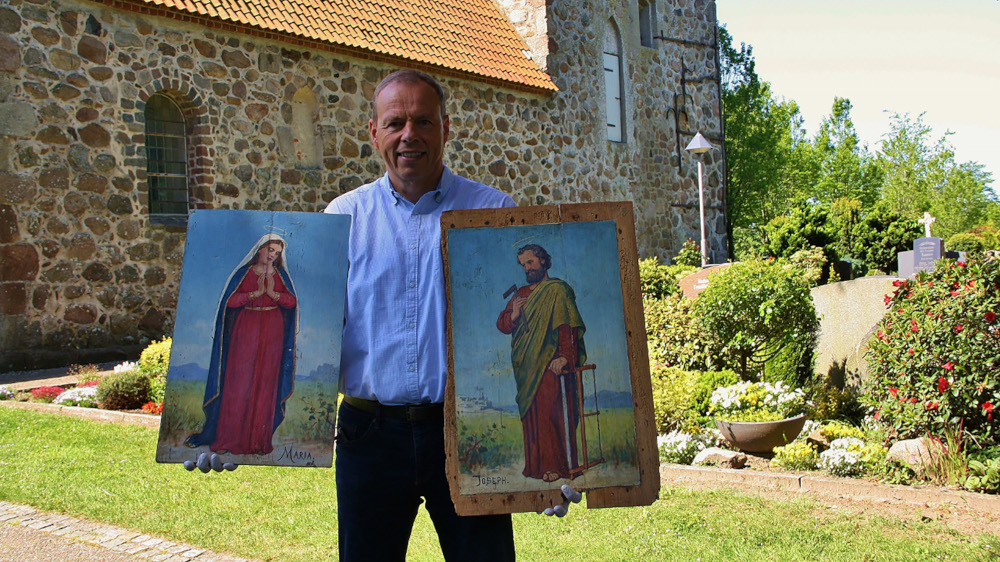 Pastor Jürgen Kaphengst fasst die beiden von Carl Ludwig Jessen gemalten Emporenbilder Maria und Josef nur mit Handschuhen an.
