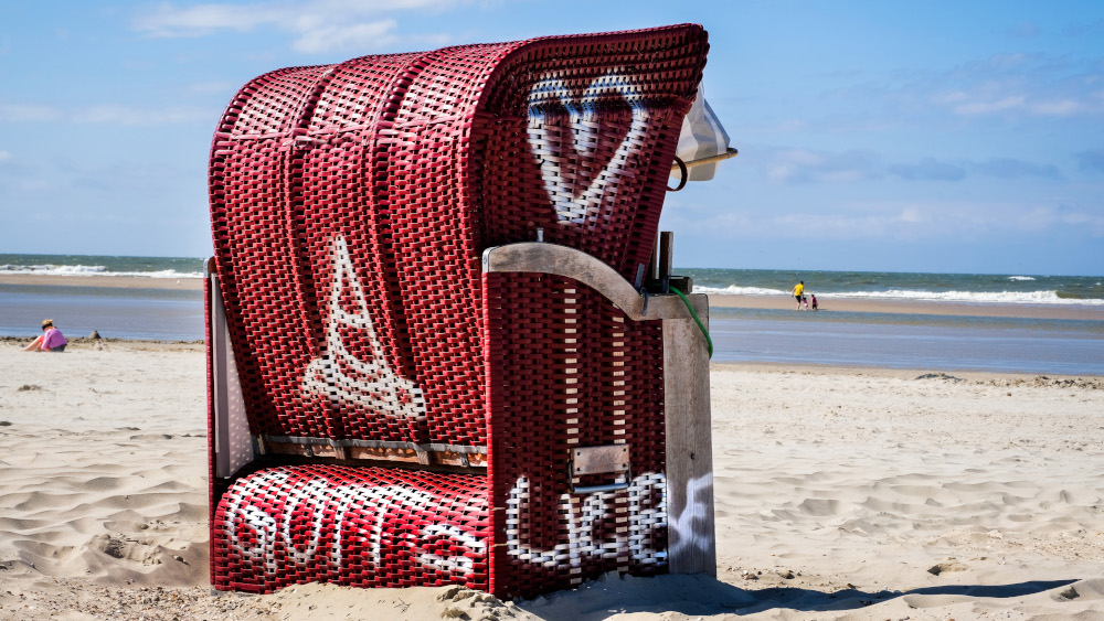 Strandkorb mit der Aufschrift "GOTT = LIEBE" am Strand der ostfriesischen Insel Spiekeroog.