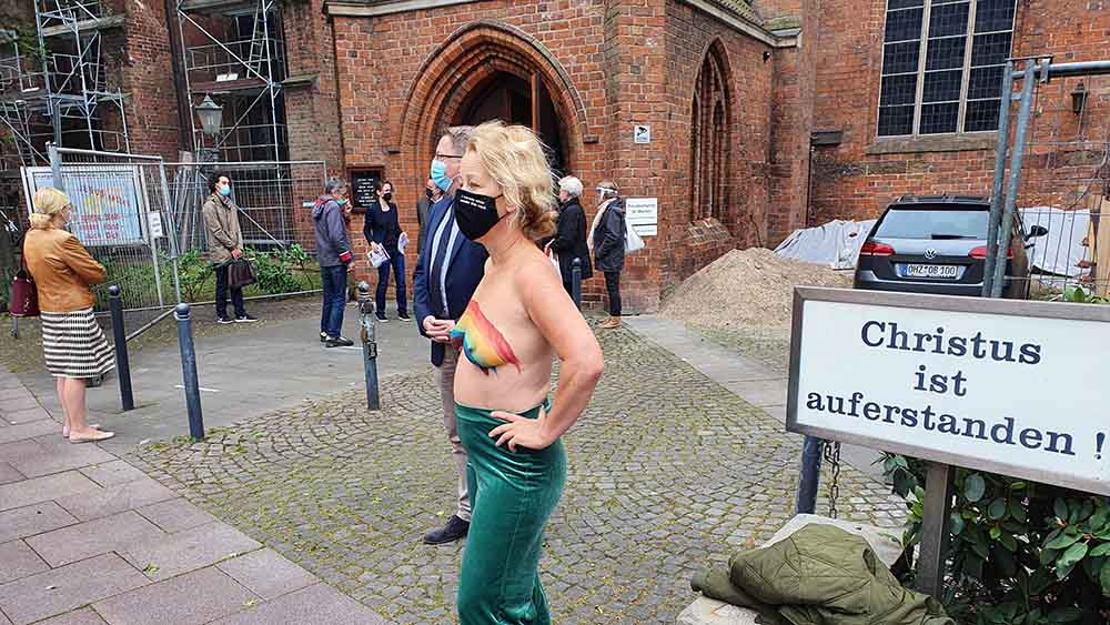 Mit nackten Brüsten in Regenbogenfarben protestiert diese Frau gegen Pastor Latzel