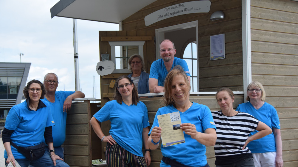 Das Team der Schäferwagenkirche um Pastorin Brigitte Gottuk (vorn) ist am Strand, mit Programm und blauen T-Shirts.