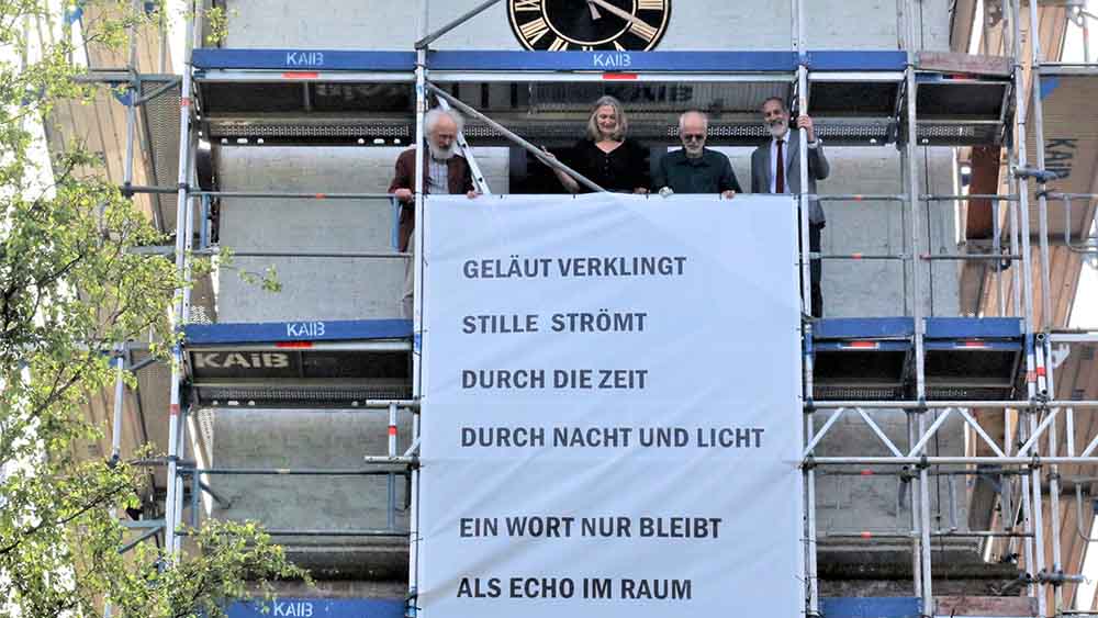 Die Initiatoren mit dem Gedichtbanner am Turm der Kirche