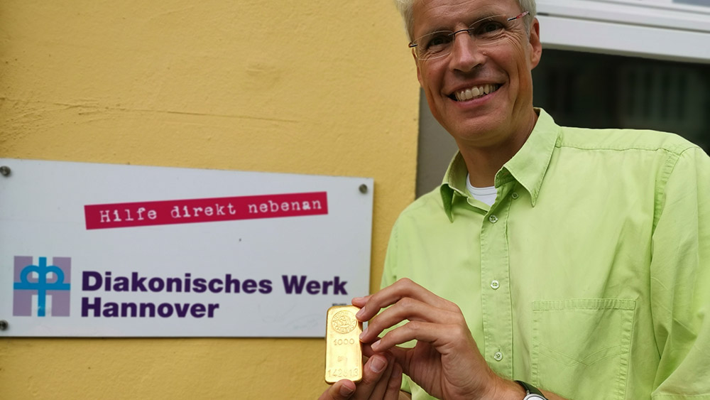 Diakoniepastor Rainer Müller-Brandes zeigt den wertvollen Goldbarren