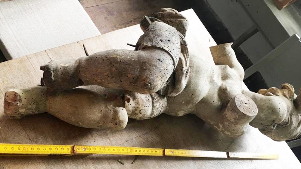 Der Engel ist von Wurmfraß gezeichnet und mit amputierten Armen