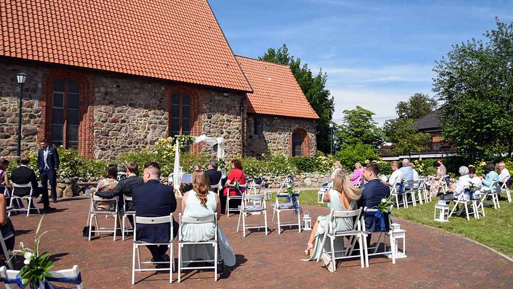Hochzeit mit Abstand: Gäste von Veronika Wintjen und Kevin Vieth im Kirchhof der St. Martin-Kirche in Oldendorf im Landkreis Stade