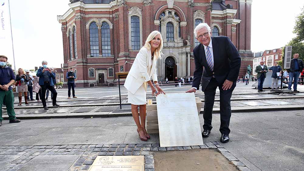 Witwe Marion Fedder und Hauptpastor Alexander Roeder zeigen die Tafel