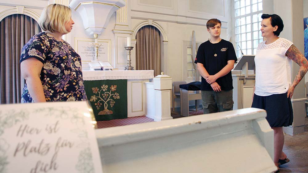 Marit Ritzenhoff, Pastorin in Wunstorf-Luthe, erläutert Konfirmand Justin Winkler und seiner Mutter Mandy das Hygienekonzept