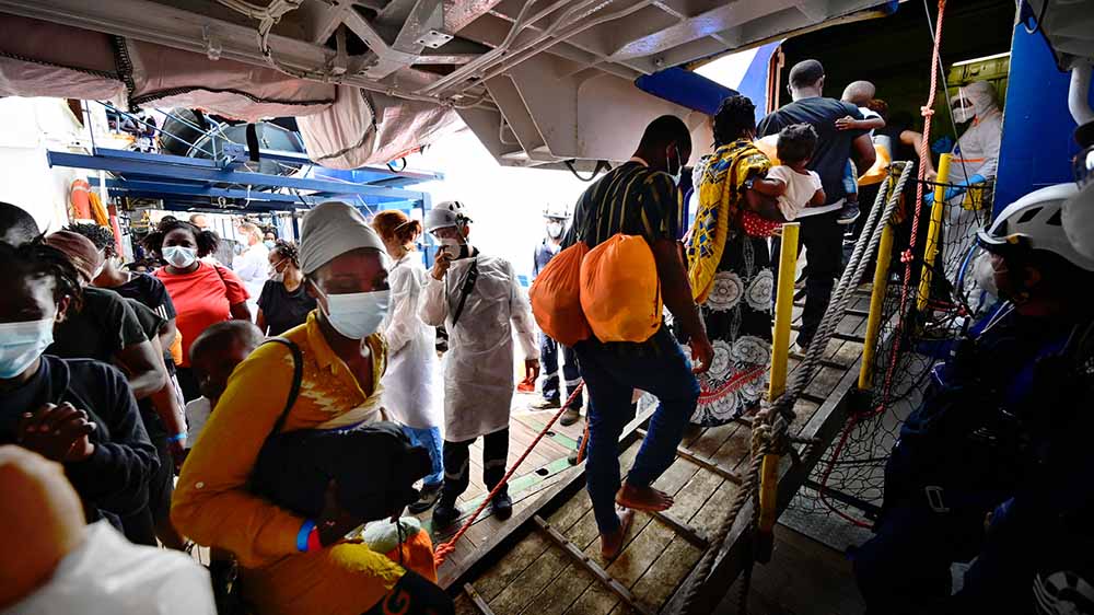 Die geretteten Flüchtlinge steigen auf das Quarantäneschiff um