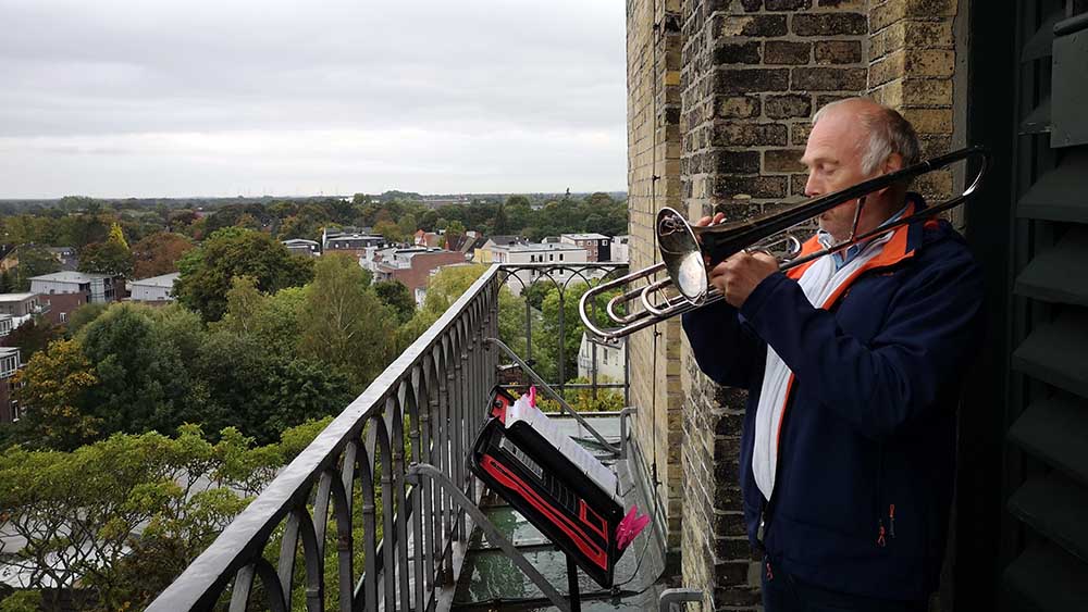 Jens Jensen spielt Posaune auf dem Turm der St.-Vicelin-Kirche in Neumünster