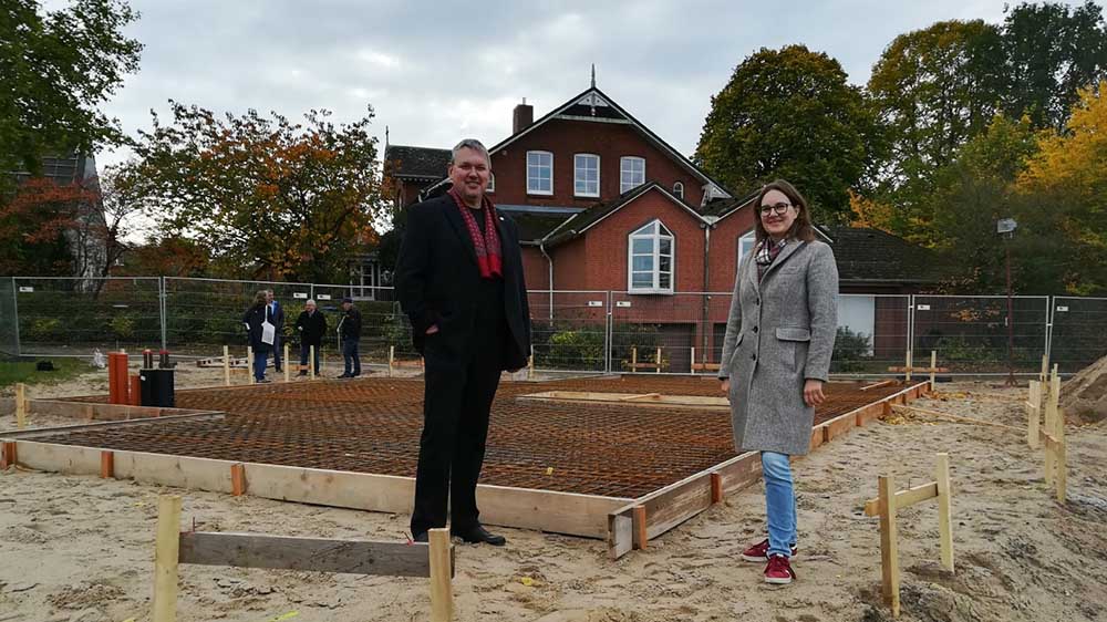 Michael Eggers vom Kirchengemeinderat und Pastorin Anna Christ vor der Bodenplatte