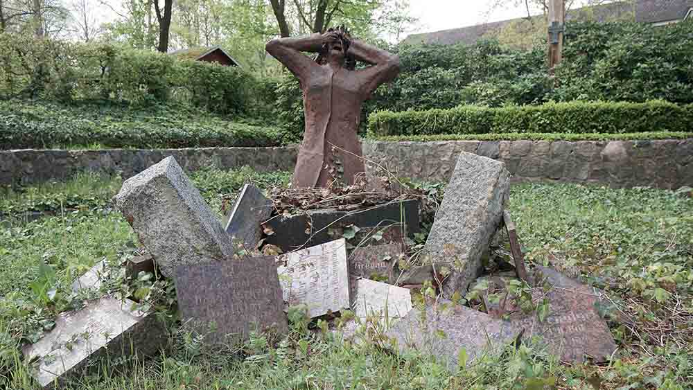 An der Fischerkirche in Lübeck wurden 2009 die Namenstafeln der toten Soldaten kreuz und quer zu den Füßen einer verzweifelten Mutter aufgetürmt