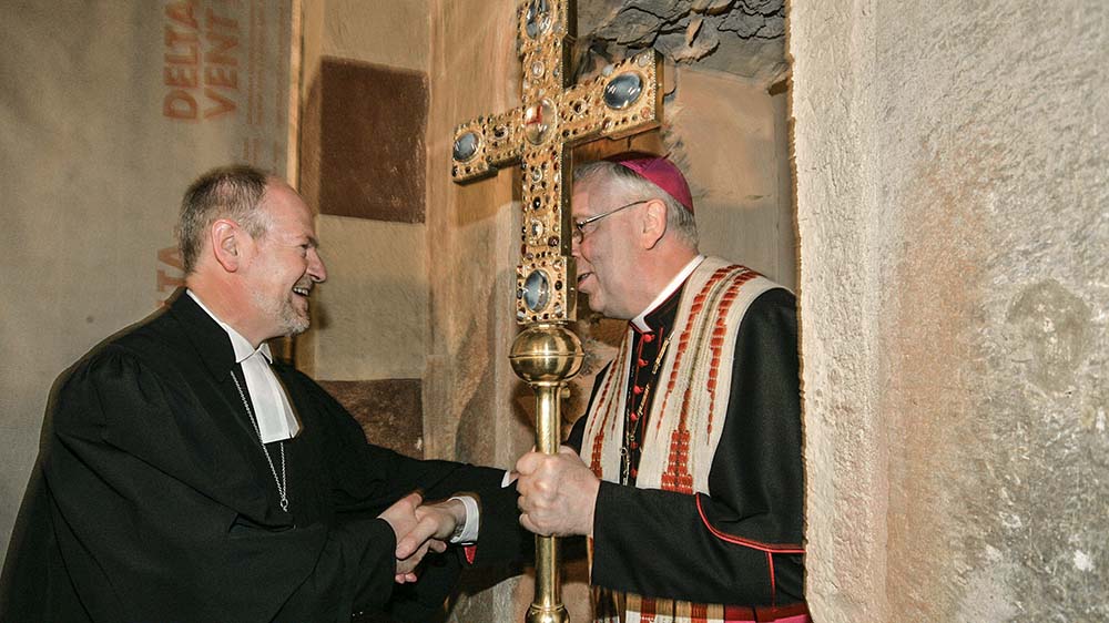 Protestanten und Katholiken reißen im Juni 2006 einer Mauer ein, die die evangelische Michaeliskirche und das katholische Michaeliskloster jahrhundertelang voneinander getrennt hat. Hier begrüßt Gorka den Bischof Trelle