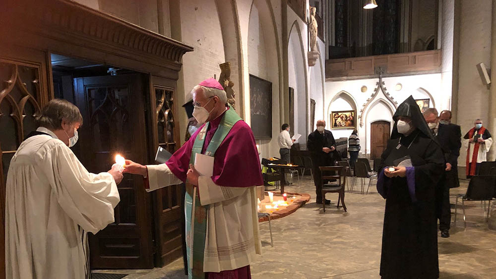 Nach dem Gottesdienst schenkt Uwe Onnen (ACK Hamburg) den Besuchern ein Segenslicht