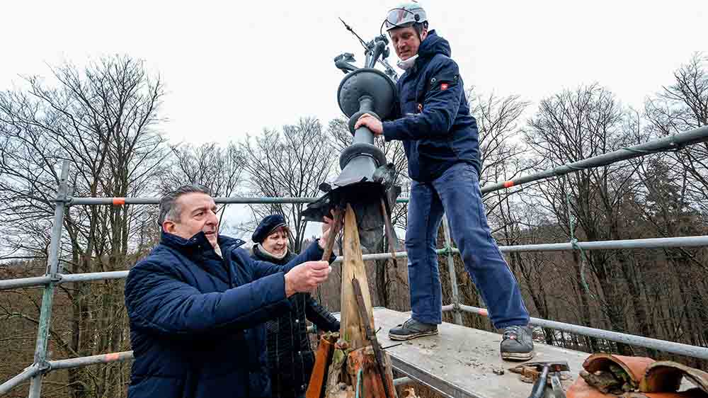 Und los geht’s (v.l.): Kulturstaatssekretär Gunnar Schellenberger, Monika Uecker vom Verein Stabkirche Stiege und Metalldrücker Thomas Müller montieren die Wetterfahne auf dem Kirchturm ab