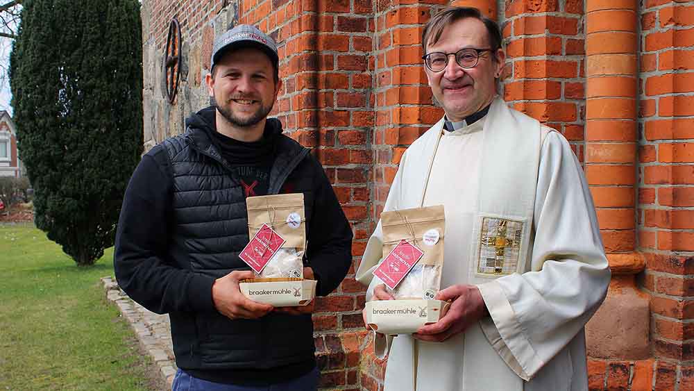 Bäcker Mark Lessau und Pastor Christian Schack mit der Backmischung