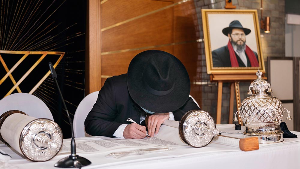 Die letzten Buchstaben werden in die neue Torarolle der Synagoge eingefügt