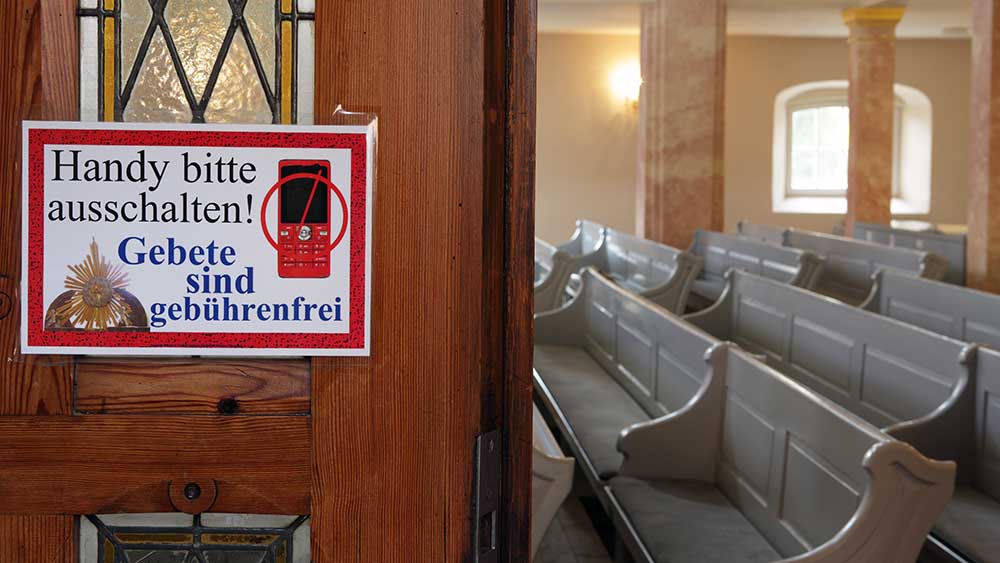 Evangelische Stadtkirche St. Georgen, Glauchau, Sachsen.  Schild am Eingang mit der Bitte, die Handys in der Kirche auszuschalten.