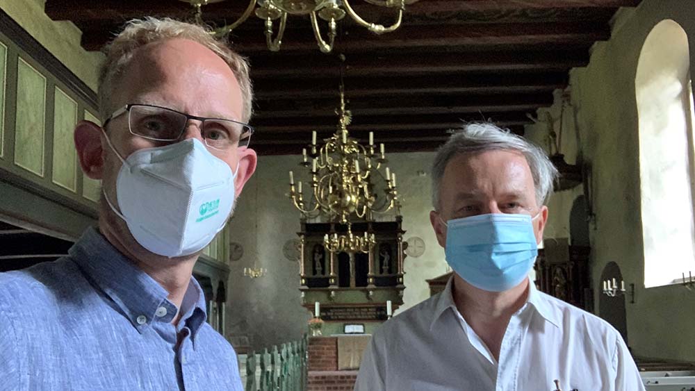 Peter-Christian Ochs (l.) vom Kirchengemeinderat und Pastor Richard Tockhorn die Sanierung der Kirche Bergstedt an