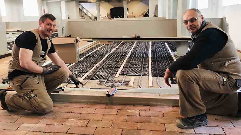 Marcel Hinrichsen (li.) und Jürgen Kreuzfeldt verlegen die Fußbodenheizung im Kircheninneren