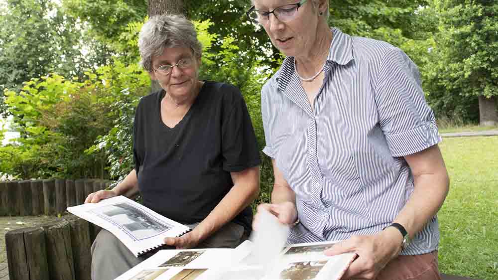 Negen Jansen (links) und Pastorin Antje Seelemeyer blättern in alten Fotoalben der Bewegung