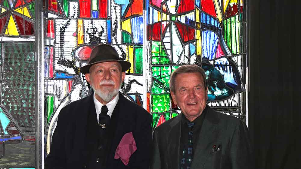 Künstler Markus Lüpertz (li.) und Altkanzler Gerhard Schröder begutachten das Fenster in der Glasmanufaktur "Derix Glasstudios" in Taunusstein bei Frankfurt