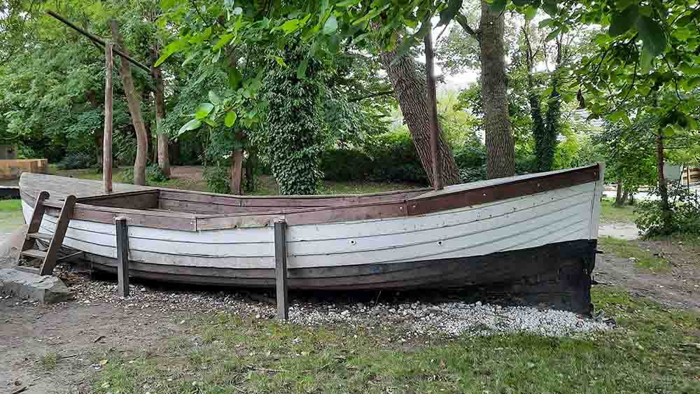 Ein Holzboot vor dem Pfarrhaus