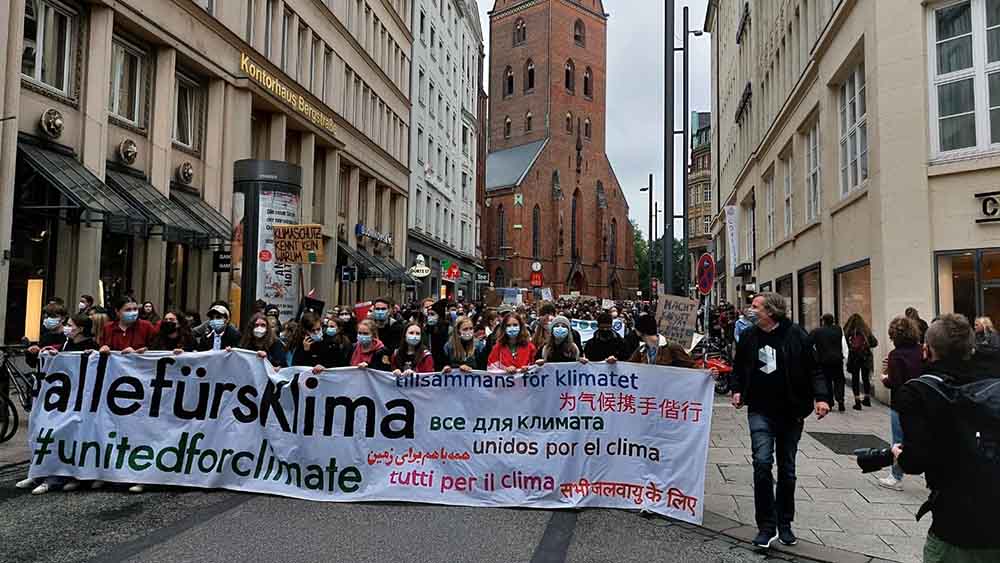 Durch die Hamburger Innenstadt mit der Hauptkirche St. Petri laufen die Demonstranten