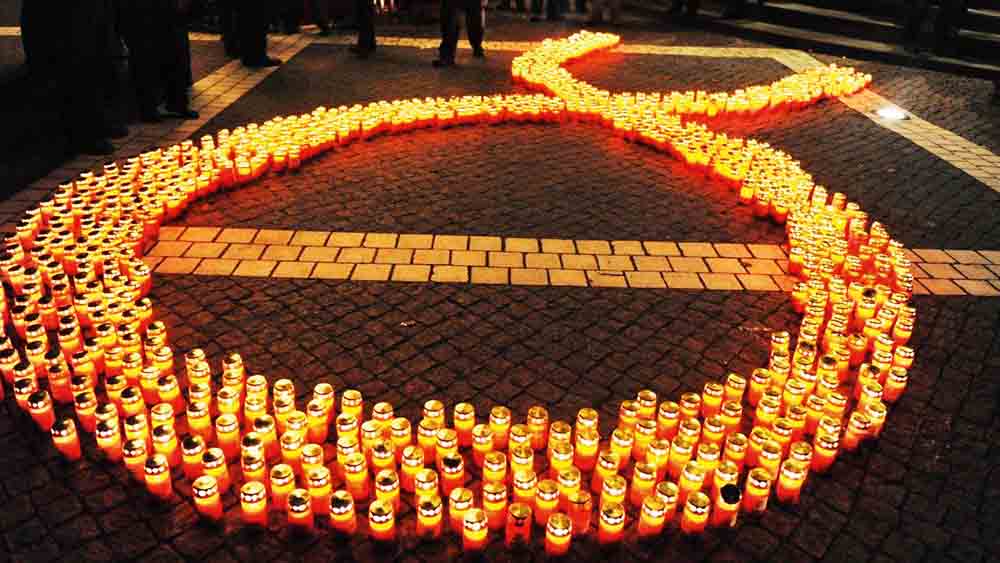 Beim Candle Light Walk in Hamburg-St.Georg formen die Teilnehmer die Aids-Schleife aus Kerzen
