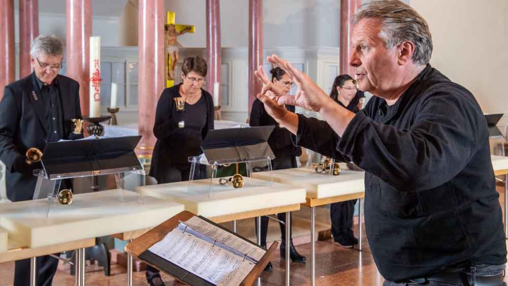 Kirchenmusiker und Chorleiter Thomas Pasemann gibt den Takt vor, und die Mitglieder des Chores lassen die Glocken klingen