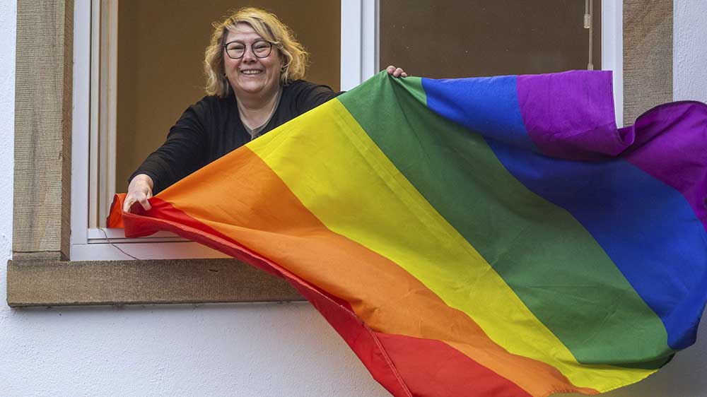 Keine Geheimnisse mehr: Ann Cathrin Röttger mit Regenbogenflagge am Fenster ihres Büros