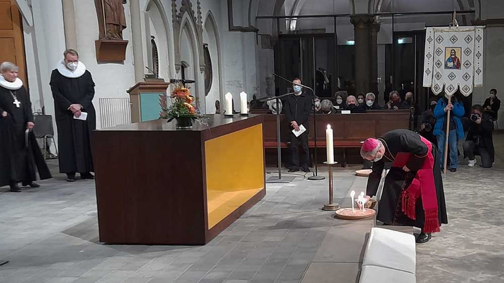 Erzbischof Heße zündet eine Kerze an