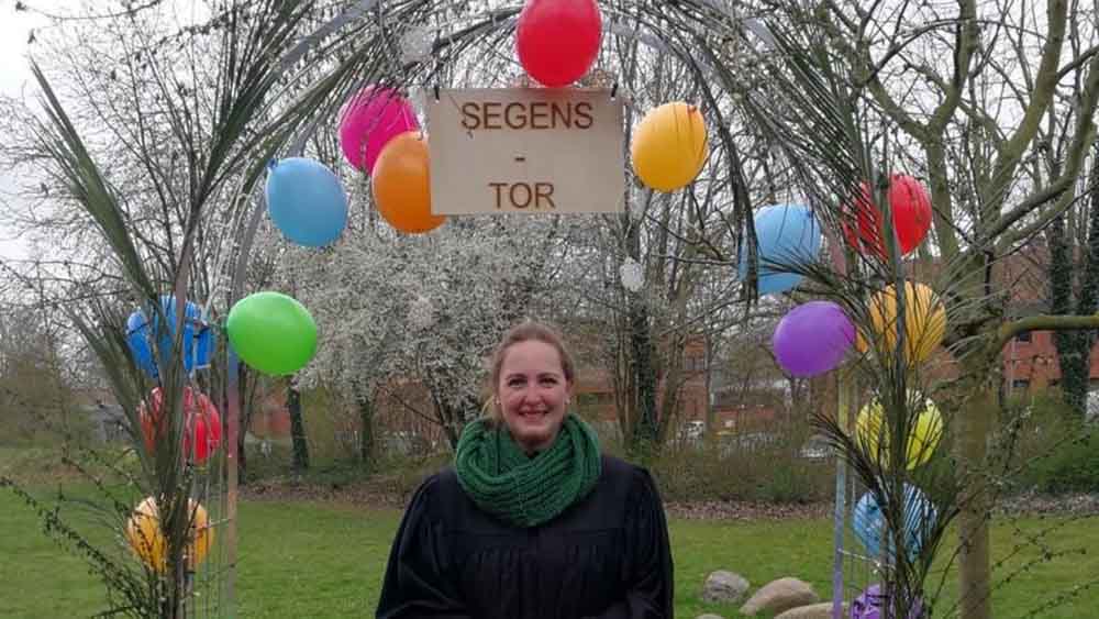 Pastorin Jasmin Zielke vor dem "Segenstor" für Gottesdienste unter freiem Himmel