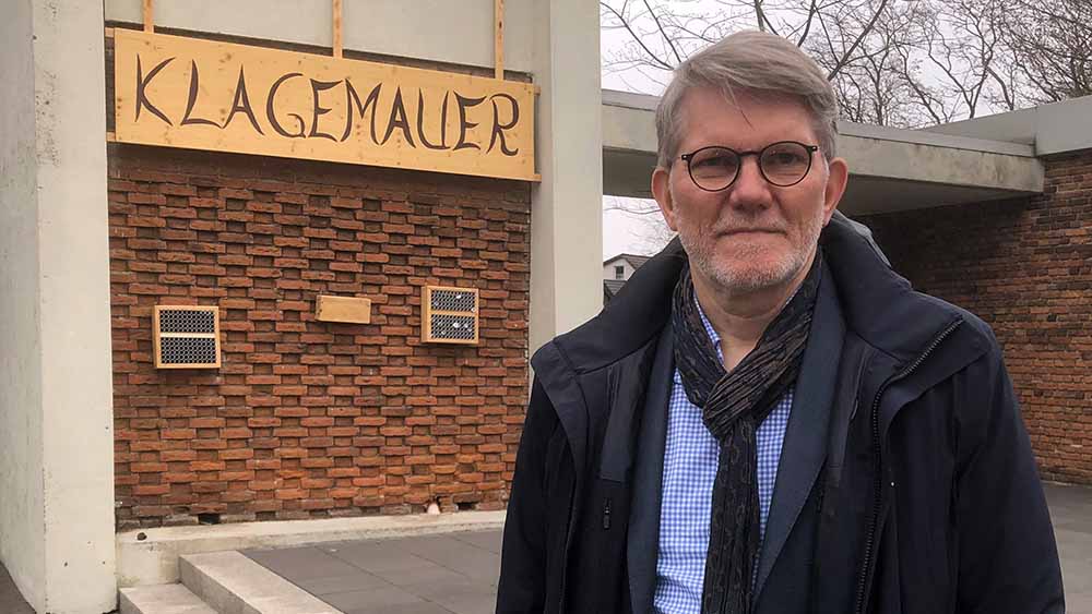 Kirchenvorsteher Harald Freystein präsentiert die Klagemauer an der Markuskirch