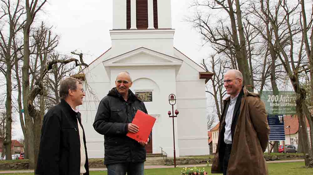 Vor der frisch sanierten Lübtheener Kirche (v.l.): Pastor Markus Holmer, Kurt Reppenhagen und Ait Stapelfeld