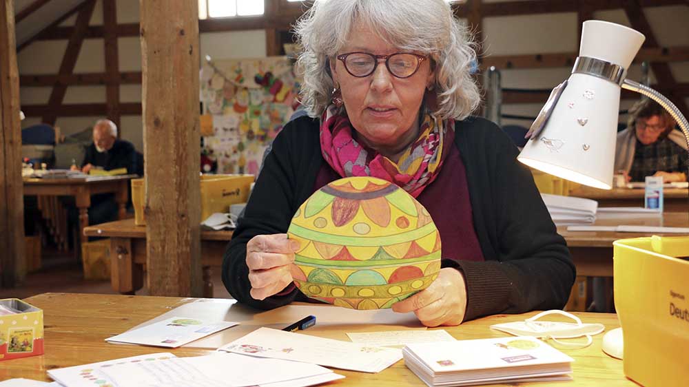 Doris Kröger, Leiterin der Osterpost-Filiale, greift selbst zum Stift