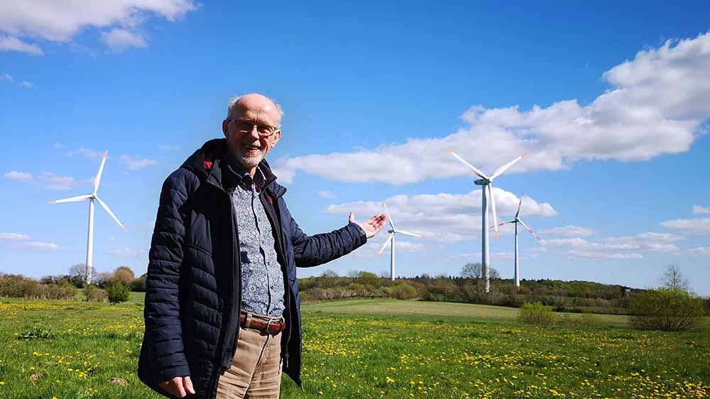 Kirchengemeinderat Rüdiger Krämer vor den Windrotoren bei Havetoft in Angeln. Ein Windrad steht auf Kirchenland