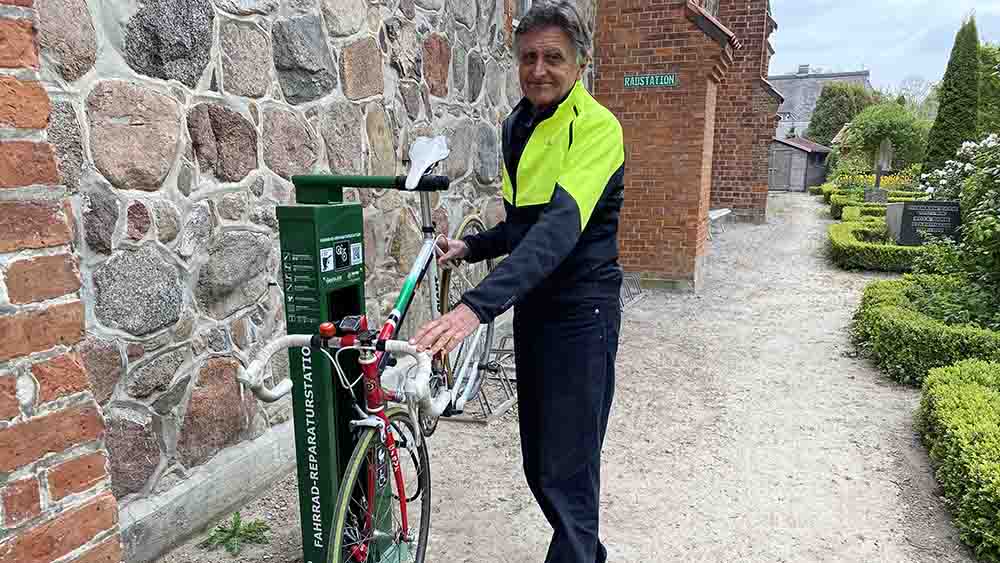 Burkhard hat sein Rad an eine Service-Station angeschlossen, direkt an der Kirche