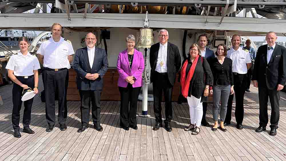 Die Landesbischöfin der Nordkirche, Kristina Kühnbaum-Schmidt, und Militärbischof Bernhard Felmberg (links und rechts neben der Glocke in der Mitte) besuchten gemeinsam mit Pröpstin Almut Witt (mit rotem Schal) das Segelschulschiff „Gorch Fock“