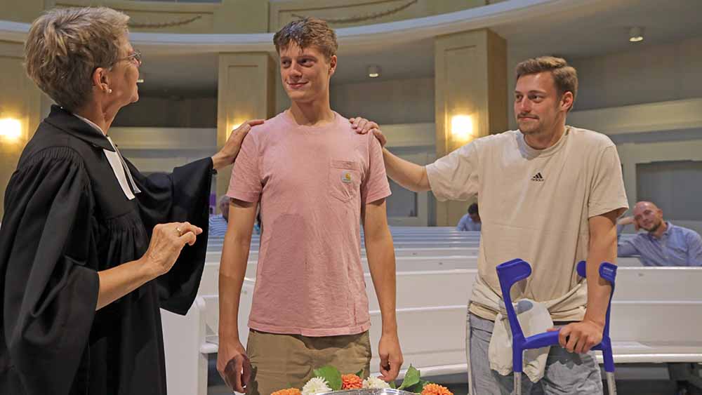 Die Brüder Alexander (M.) und Christian Rieck lassen sich von Pastorin Susanne Duwe taufen