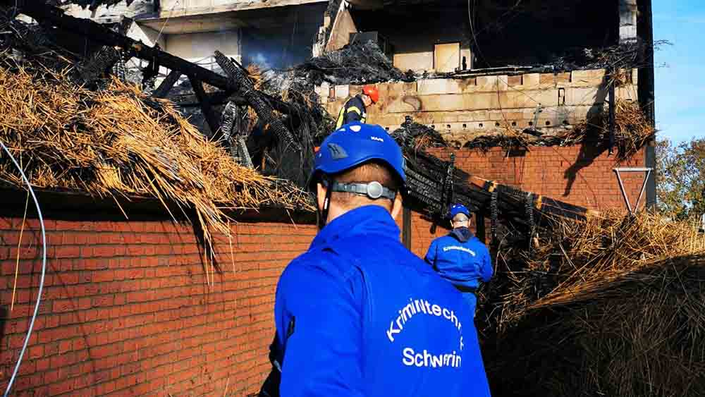 Kriminaltechniker suchen am Brandort nach Beweisen