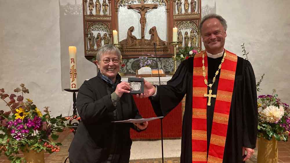 Elke König und Bischof Tilman Jeremias zeigen die Bugenhagenmedaille