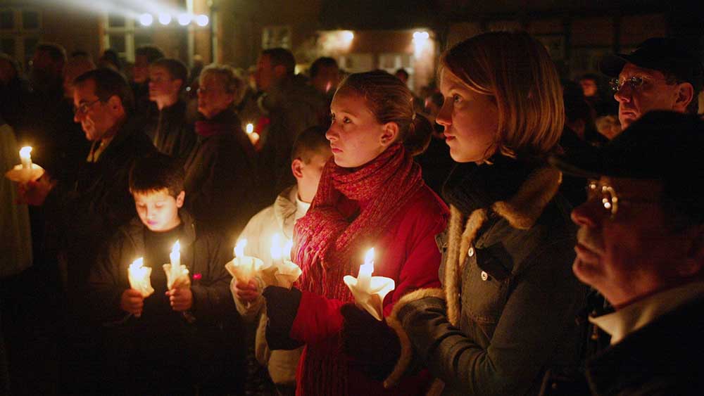 Zum zehnten Jahrestag im November 2002 zünden die Menschen Kerzen auf dem Marktplatz an
