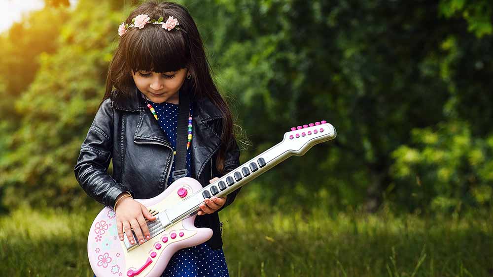 Mädchen spielt auf Gitarre für Kinder
