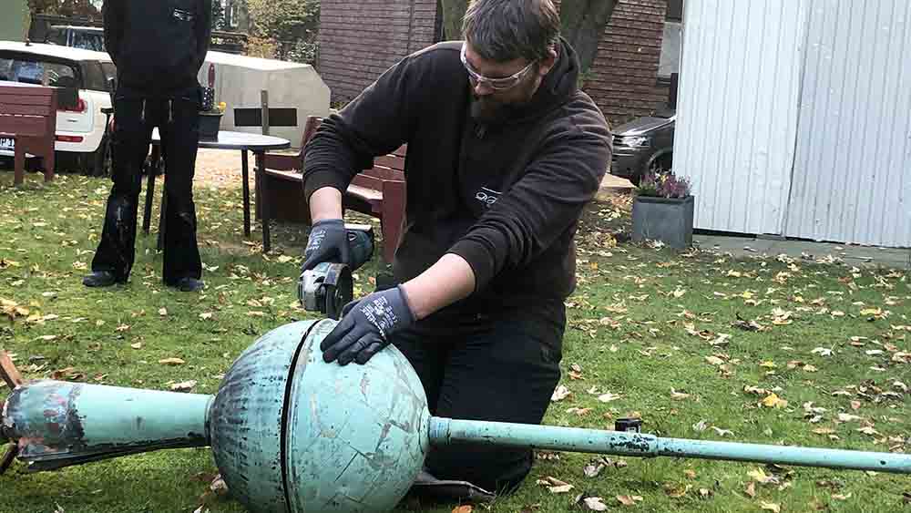 Vorsichtig öffnet ein Arbeiter die Kapsel