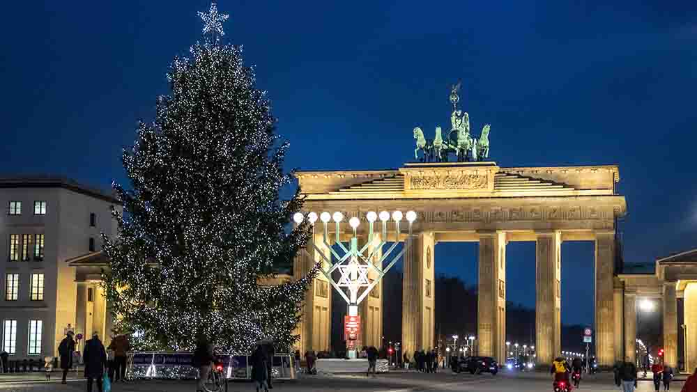 Vor dem Brandenburger Tor strahlen im Dezember 2021 ein Chanukka-Leuchter und ein Weihnachtsbaum